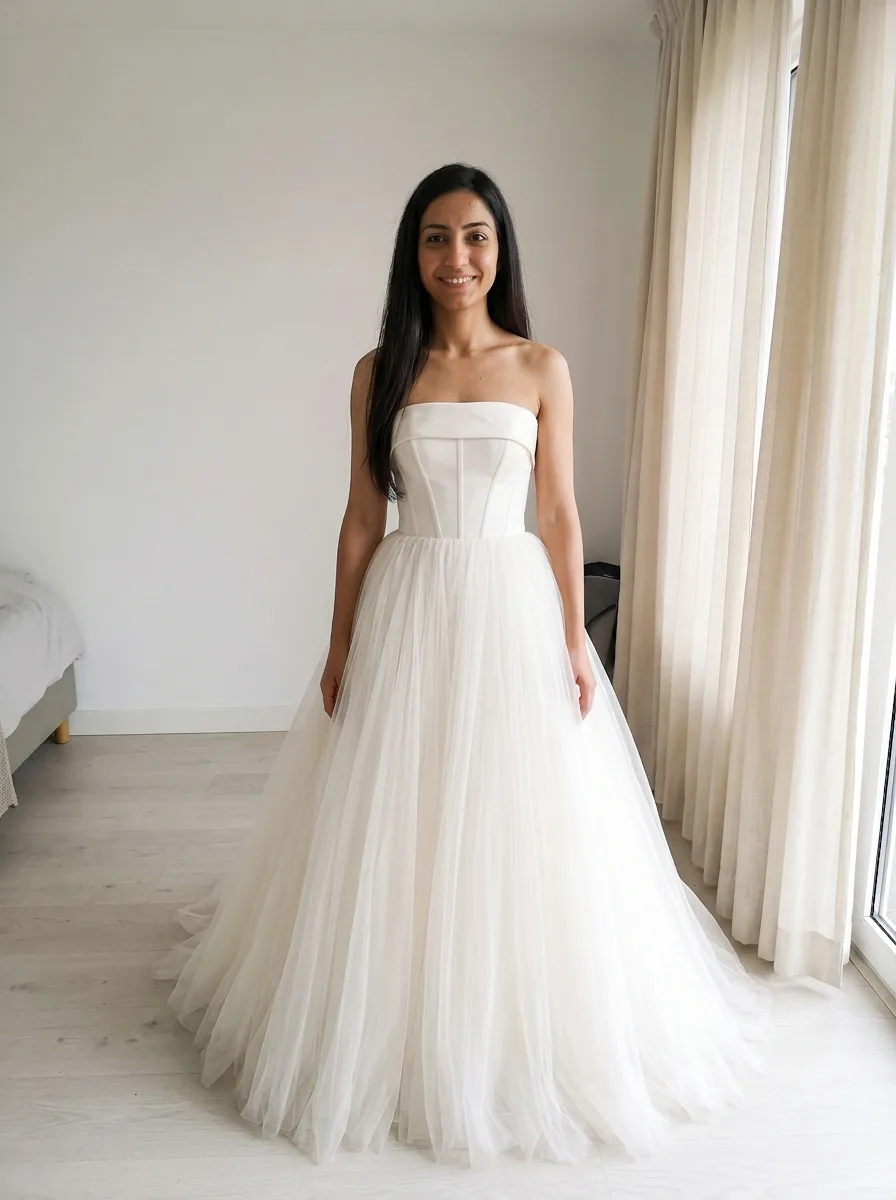 The same woman wearing a strapless ball gown with a structured satin bodice and a full tulle skirt