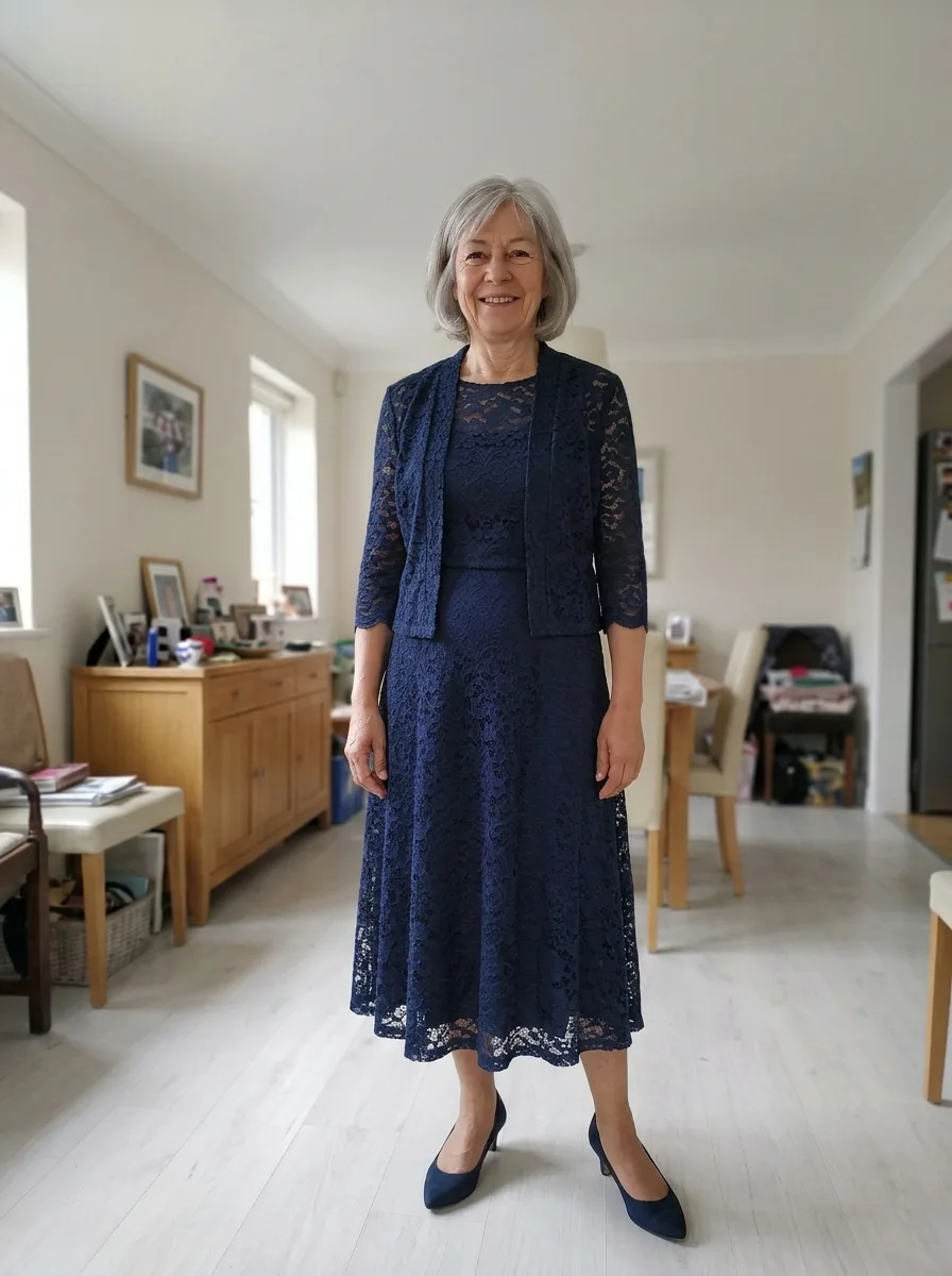 The same woman wearing a navy lace tea-length dress with a matching short lace jacket